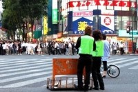 新宿・歌舞伎町のメインストリート「セントラルロード」。夕方６時、黄緑のベストをつけた集団が近づいてくると、道をふさいでいた黒いスーツの男たちは一斉にその場から散っていった。

